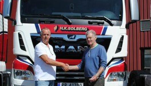 Steinar Solberg, eier og daglig leder i H. K. Solberg Transport AS (til høyre), mottar seks nye MAN TGX 26.580 fra Johannes Erlandsen, salgskonsulent for MAN Truck & Bus Norge AS i Kristiansand.