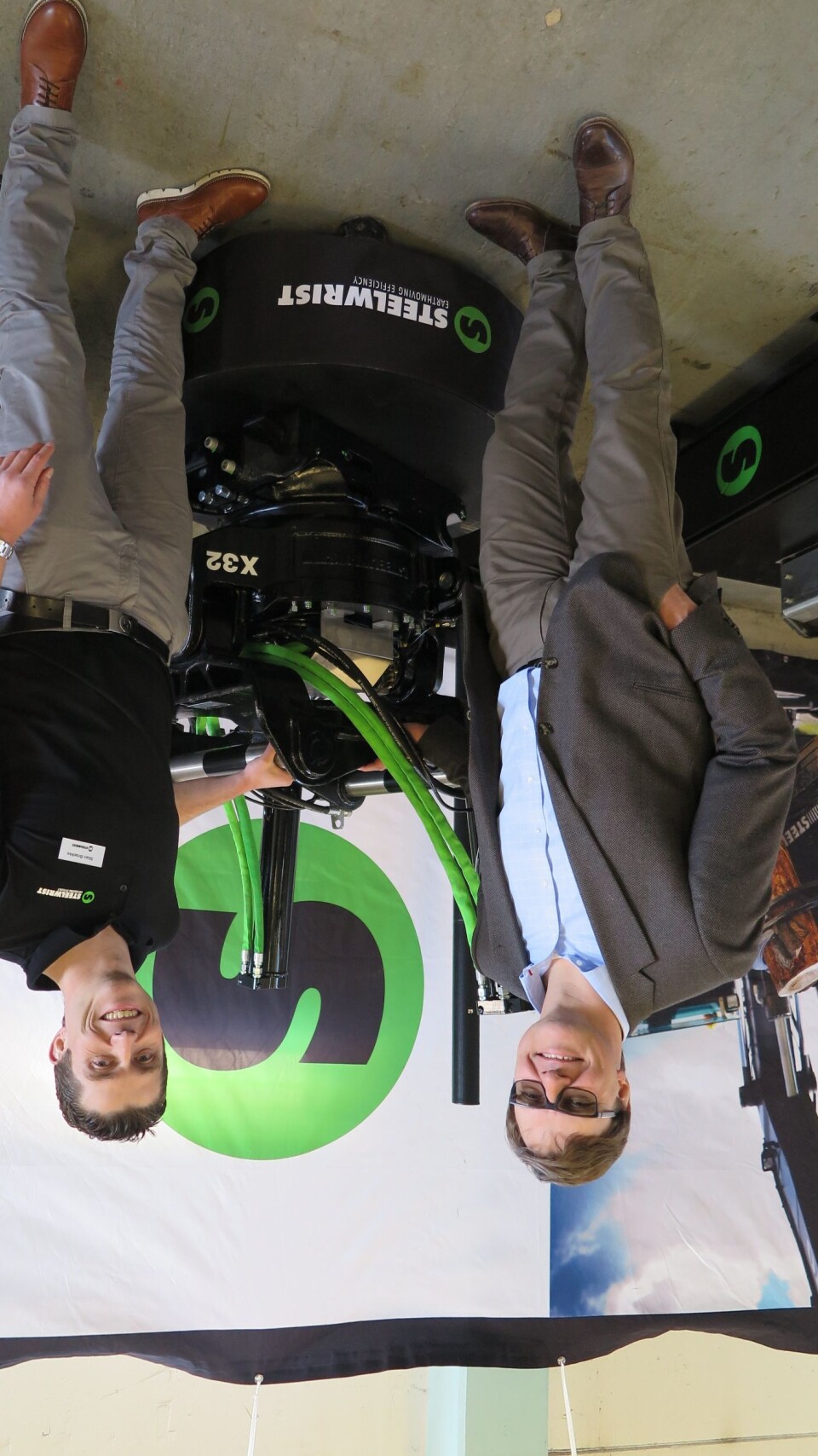 En stolt og lettet Steelwrist-sjef Stefan Stockhaus (t.v.) og Norges-leder Stian Brække foran tiltrotatoren X32 som kom allerede i 2014, men nå har fått fast OQ-topp. Redskapet har lav byggehøyde, vekten er lav, men styrken er økt.