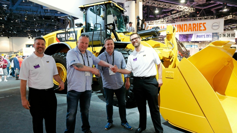 Det ble kjøp av en Cat 966M XE-hjullaster. Her er det «shake hands» på Cat-standen. Fra venstre: Mike Spielman (Caterpillar), Rune Madsen (Roald Madsen AS), Per Gunnar Hansen (Pon Equipment) og Ben Schmuck (Caterpillar).