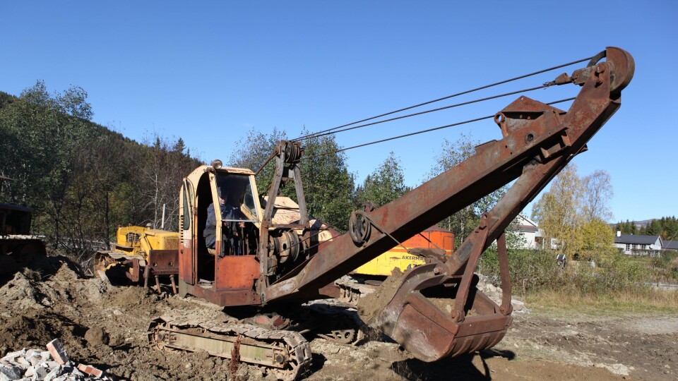 Håkon Kråbøl graver med en Ruston-Bucyrus 10-RB som ble kjøpt av bestefar Arnfinns firma i 1958. Takket være mekanikerne Håkon, Anders og Arne Kråbøl fungerer den fint. Det er et godt stykke fra komforten i denne maskinen til dagens gravemaskiner. I 10-RB utføres justering av setet ved å skru det løs og flytte det til et annet hull i gulvet.