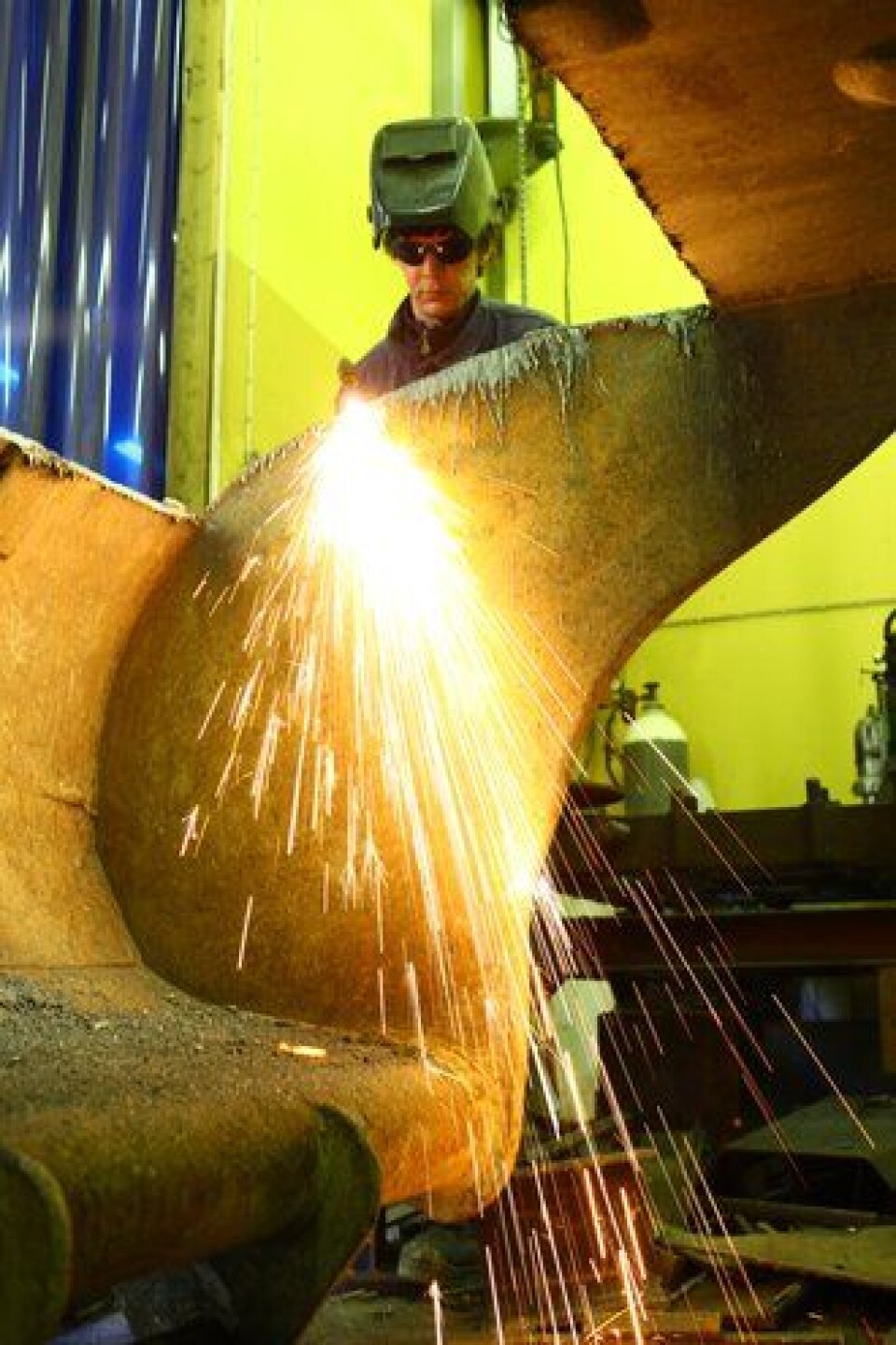 Håkon reparerer maskiner og utstyr på bestilling. Her er han i ferd med å skifte bunn i ei gravemaskinskuffe for en kunde.