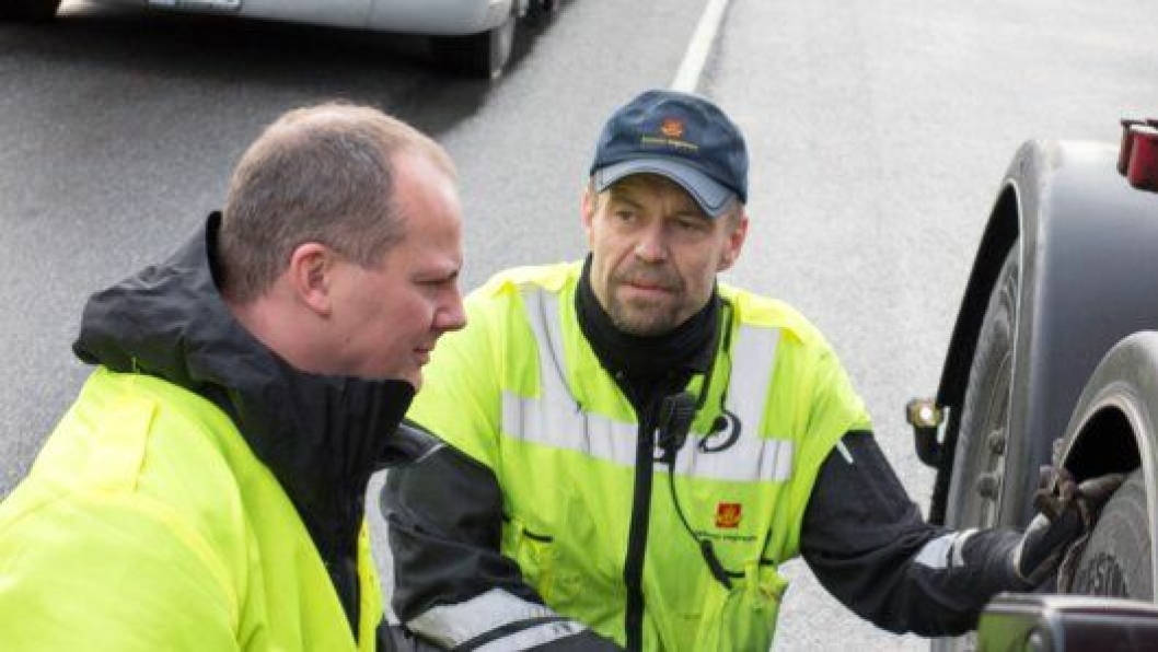 Samferdselsminister Ketil Solvik-Olsen inspiserer dekk under tungbilkontroll på Svinesund. Til høyre kontrollør Roger Gulvik fra Statens vegvesen.
