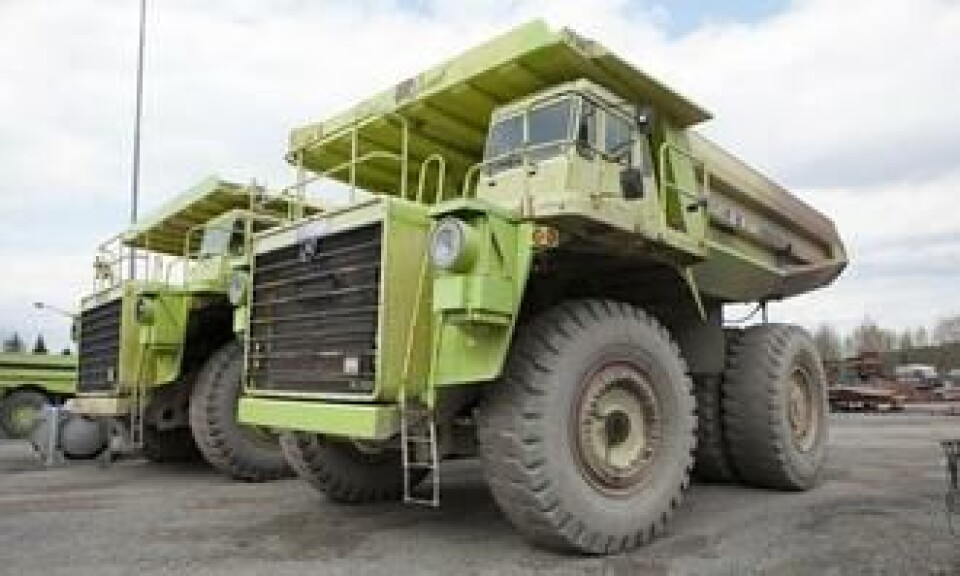 De to grønne tipptruckene hviler seg etter dagens innsats.