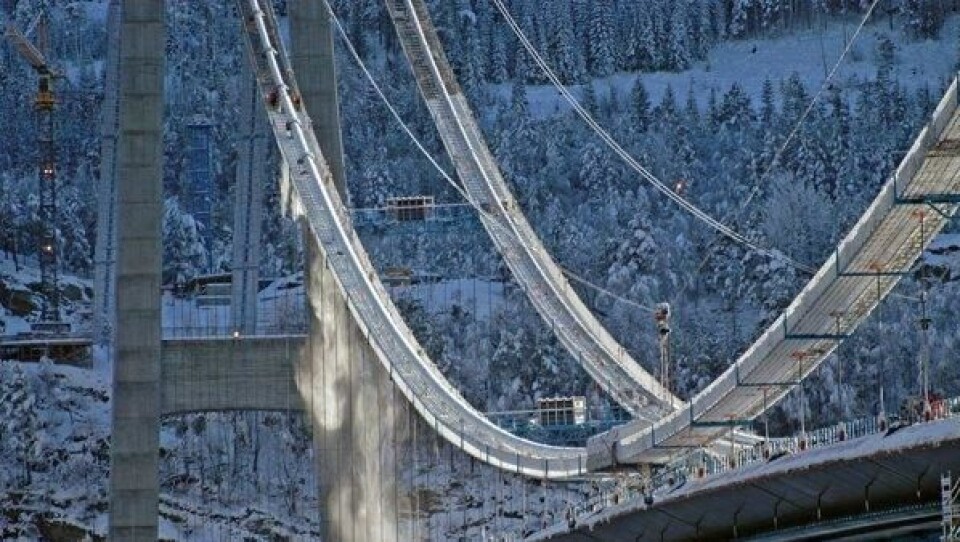 Stemningsfullt snødryss på brua når snøen blir ryddet fra platformen ved kabelen.