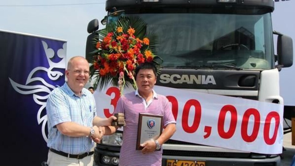 Adm. direktør i Scania China Strategic Office, Mats Harborn, overrekker gullpris til Xu Yurong hos transportselskapet Qingfeng.