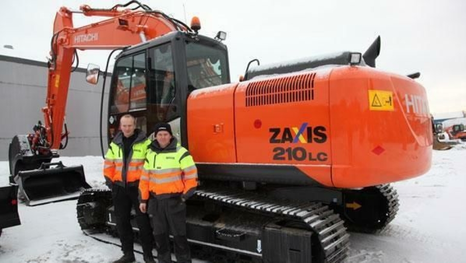 Nastas Lennarth Haga Lie (t.v) og Kjetil Tveiten foran den nye 21-tonneren ZX210-5 som nå er i Norge.