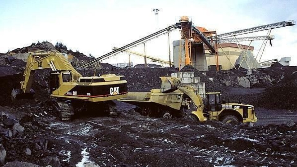 CAT 980G og CAT 375 beltegraver laster CAT 775D truck som transporterer stein fra bruddet til grovknuser eller mellomlager. Bak sees deler av det nye prosessanlegget.