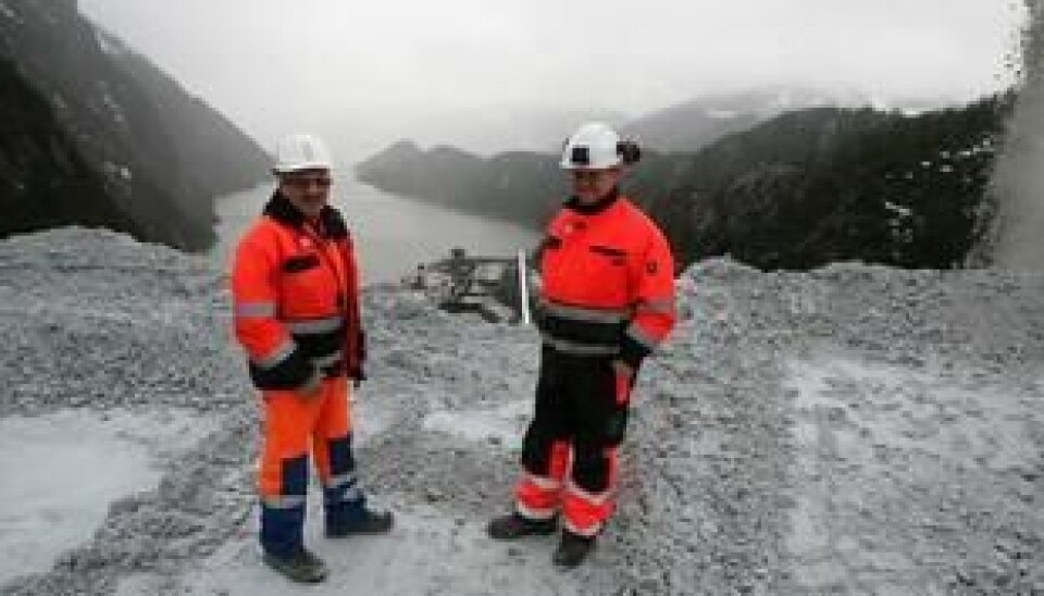 Knut Fjelldalselv (t.v) og Raymond Langfjord er skiftledere og er kun på jobb sammen til ære for A&Ts fotograf. Til høyre står «kalksteinstrålen» fra knuseverket. Steinen tas videre på transportbånd til skipet nedenfor.