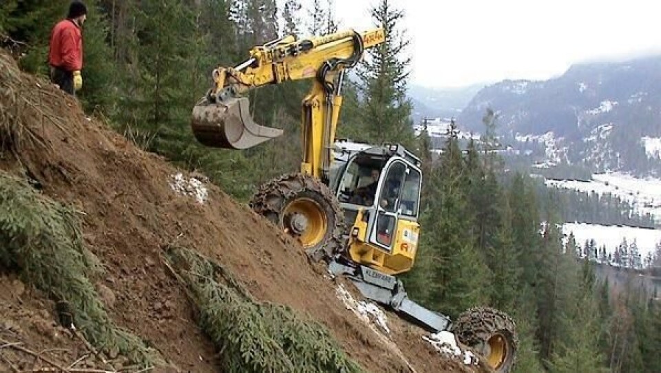 Den terrengsterke Menzi Muck’n og maskinfører Roar Nyvoll i det bratteste partiet. Med ryggen mot Begnadalen, og 37 graders helning, skal Nyvoll grave seg nedover det 350 meter lange bratthenget ned mot kraftstasjonen.