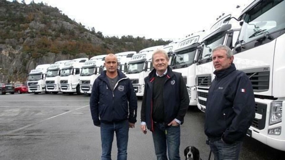 Veøy – selskapene har siden i høst tatt i bruk mer enn 100 nye Volvo lastebiler. Bildet er fra overleveringen av ikke mindre enn 21 nye Volvo FH trekkvogner, som foregikk på Trucknors anlegg i Kristiansand. På bildet ses fra venstre daglig leder i Veøy Sør, Rune Slemmen, med hunden Dolly, trafikkleder Øystein Slåen og selger i Trucknor, Reidar Sines.