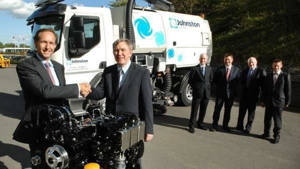 Administrerende direktør, Malcolm Sandford i JCB Powertrain (foran til venstre), og daglig leder i Johnston Sweepers, Coen van Rosmalen, inngår avtale om bruk at motorer fra JCB i Johnston Sweepers sine feiebiler. I bakgrunnen står (fra venstre) produktsjef Steve Douglas (Johnston Sweepers), salgssjef Robert Payne (JCB), direktør for motoravdelingen Alan Tolley (JCB), senior motoringeniør Dan Taylor (JCB).