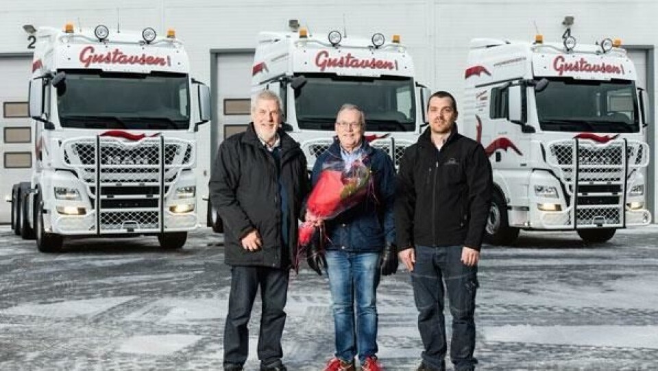 Daglig leder Ian Gustavsen (i midten) og Driftsleder Aslak Gustavsen (til høyre i bildet) får overrakt blomster av selger John Hunsrød hos MAN i Larvik.