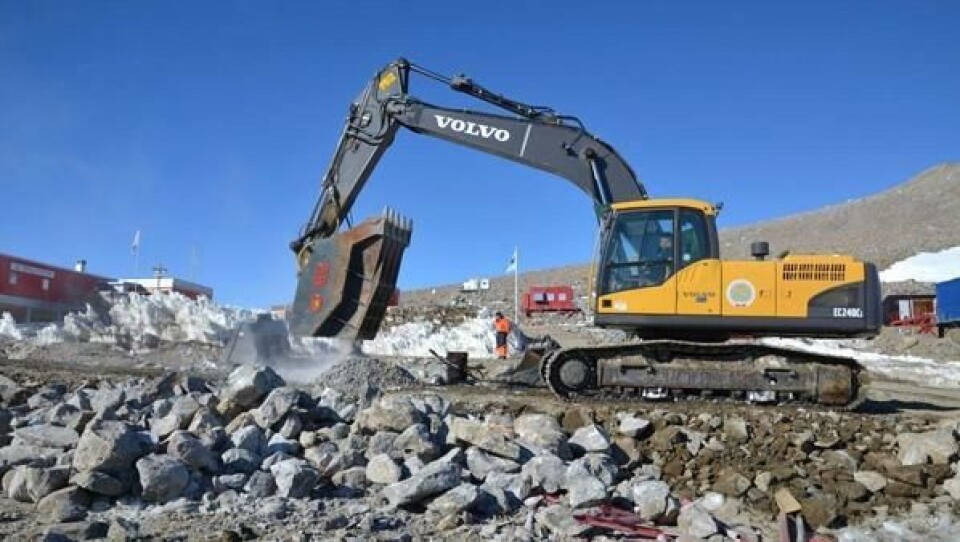 Volvo-gravemaskin i arbeid med knuseskuffe ved forskningsstasjonen Troll i Antarktis
