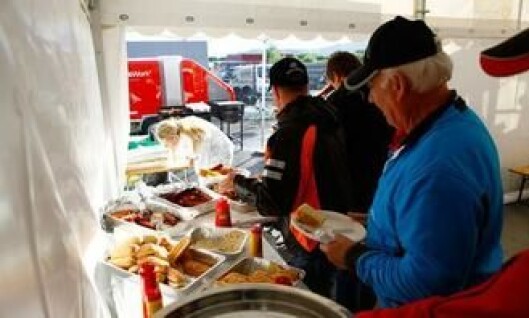 Grillmaten ble delt ut i et partytelt. Grillmaten ble delt ut i et partytelt.