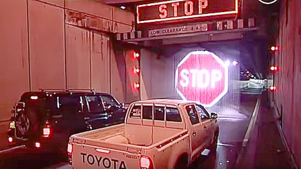 Veimyndighetene i Sydney har laget vannfall som projekterer et lysende stoppskilt ved tunnelåpninger når et for stort kjøretøy nærmer seg tunnelen. Illustrasjon: Channel Ten