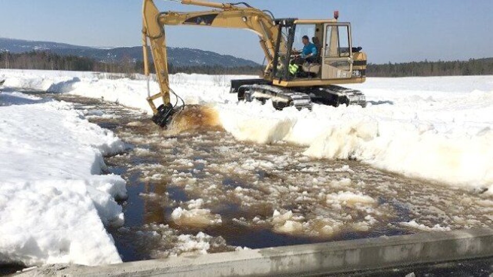 Driftstekniker Knut Arne Hansen i skytefeltadministrasjonen fjerner is på Ygla. Maskinen står på vollen som er bygget av Forsvarsbygg.
