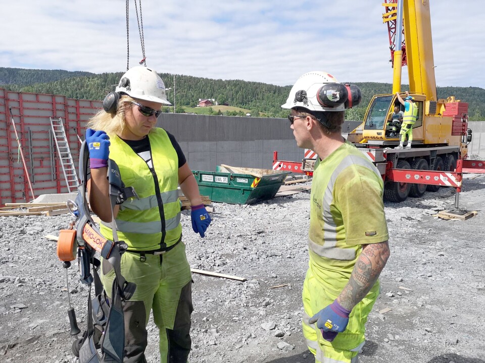 Julie i samtale med en av sine menn i betonglaget, Trygve W Kvernmo, mens hun setter på seg sikkerhetsselen til liften.