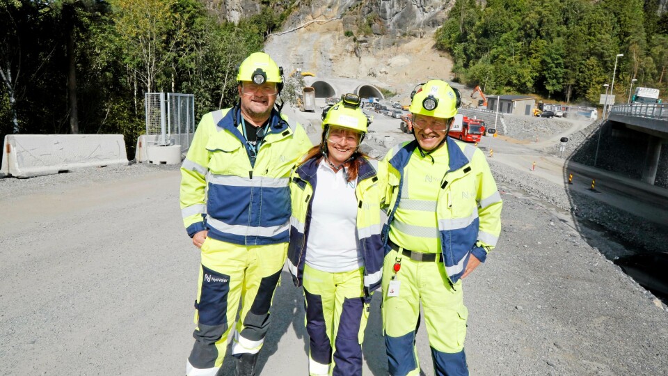 RASK JOBB: Tunnelåpningen i Bamble i sør i bakgrunnen. I fjellet sees «jordskillet» der 130.000 kubikkmeter løsmasser måtte graves bort for å lage portal. Fra venstre er Nye Veiers Ingvald Hundhammer (kontrollingeniør tunnel), Ruth Haug (utbygningssjef for prosjektet) og Søren Bekkhus (kontrollingeniør dagen).