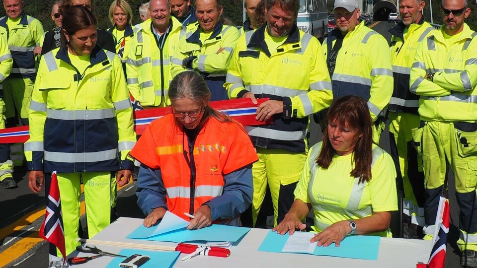 Det var åpning med båndklipping, norske flagg og overtagelse av veien til Statens Vegvesen. Leder for plan- og forvaltningsseksjonen i Statens vegvesen Telemark, Eivind Gurholt og Ruth Haug, utbyggingssjef E18 Kjørholt og Bamble tunneler signerte overtakelsespapirer. Til venstre for dem står adm. direktør i Nye Veier, Ingrid Dahl Hovland.
