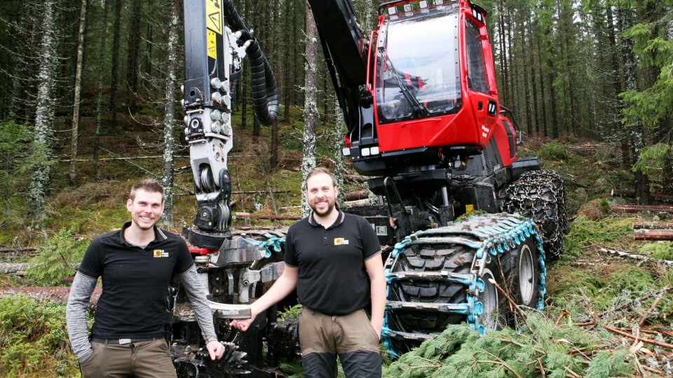 «GRENSEHOGST»: Marius (t.v.) og Erik Heggedal med den nyeste hogstmaskinen, Komatsu 901XC, som er i drift rett ved svenskegrensen.