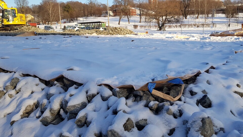 Bildet viser hvordan entreprenører valgte å bruke snøseil til å dekke et område før støping av en betongflate på ca. 1700 kvadratmeter. Snø på bakken ville skapt merarbeid og ekstrakostnader for entreprenørene når isolasjon og armering til betongplaten skulle legges. Med seilene kunne snøen løftes bort slik at bakken fortsatt var bar før jobben startet.