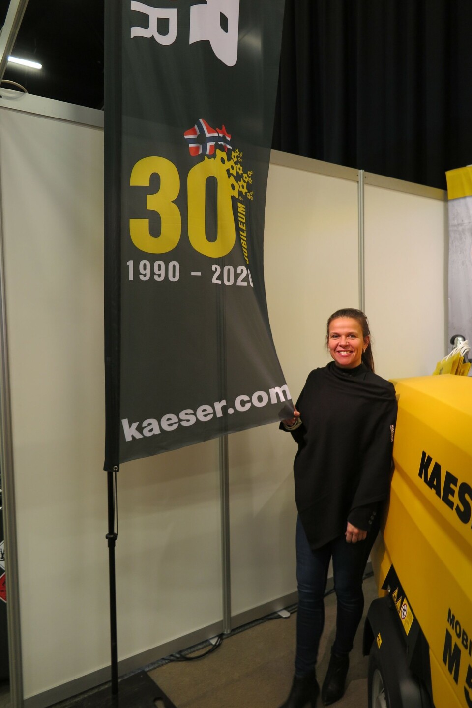 Markedskoordinator hos Kaeser Kompressorer AS, Cathrine Brich, med jubileumsfane på Arctic Entrepreneur 2020 på Gardermoen.