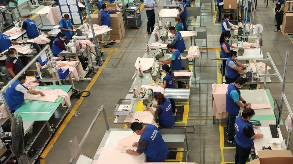 Ford-ansatte syr beskyttelsesfrakker av kollisjonsputemateriale.