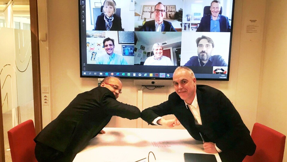 Digital signering med alternativt håndtrykk. F.v: Prosjektdirektør i Nye Veier, Johan Arnt Vatnan, og Pablo García Caramés, finansdirektør for Norge i Acciona. På skjermen ser vi flere fra ledelsen til de to selskapene: Anette Aanesland, administrerende direktør i Nye Veier er oppe til venstre i skjermen.