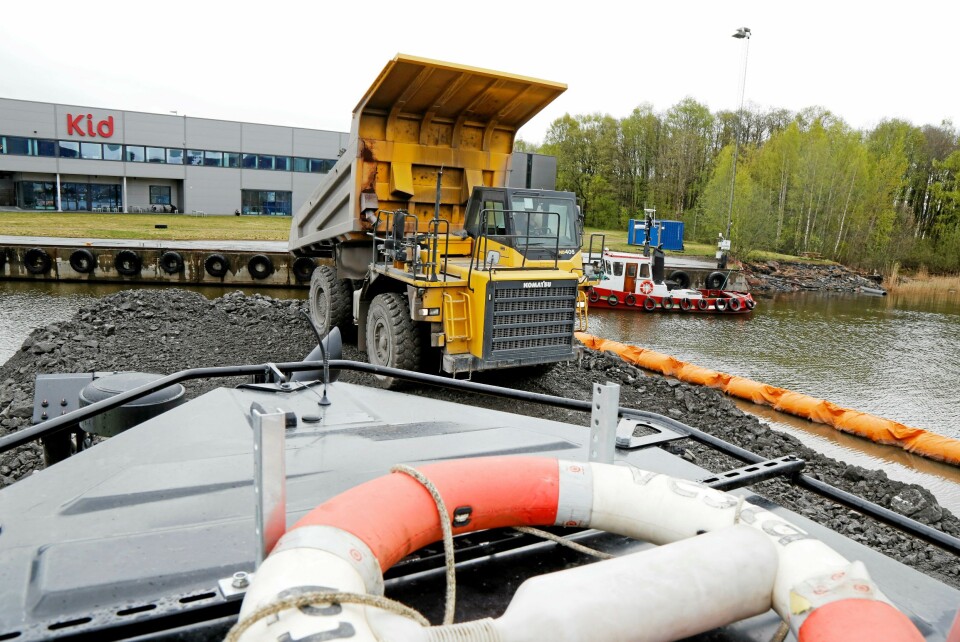 TIPPER: Tipptrucken legger igjen ca. 50 tonn stein som dozeren, med livbøye på taket, skal skyve videre ut i vannet.