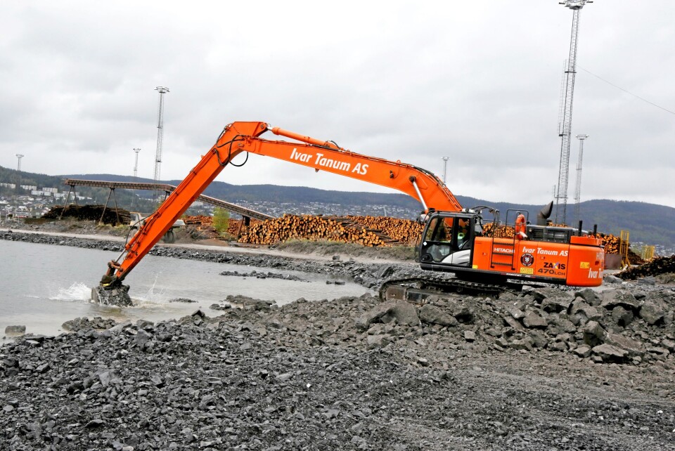 LANGARMET: Hitachi 470-graveren med 22 meters graveaggregat veier ca. 60 tonn. Maskinen løfter stein langt ut i vannet.
