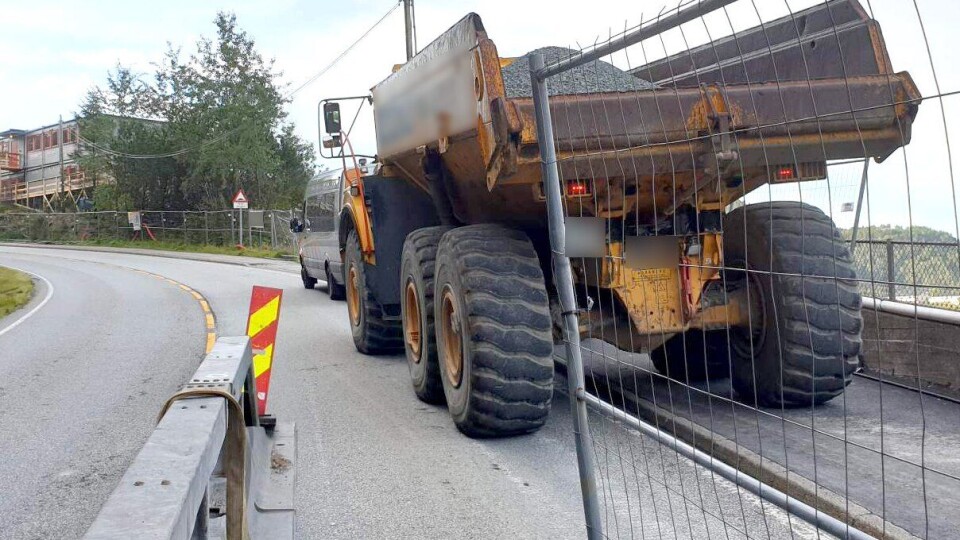 Dumper med svarte skilt på offentlig vei.
