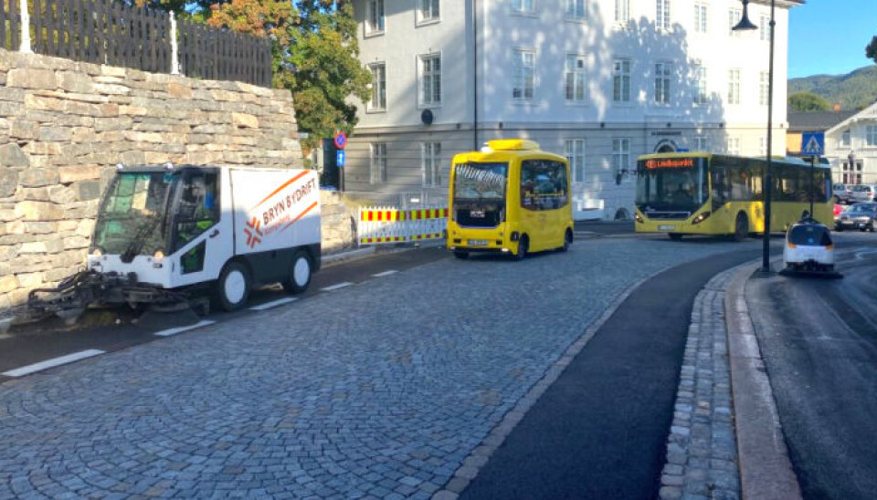 Feierobot sammen med buss, selvkjørende buss og vanlig feiemaskin i Kongsberg sentrum.