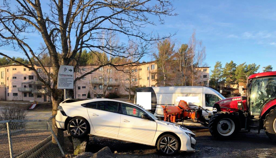 Personbilen har fått en solid dytt bakover opp på en stein og et gjerde. Både personbilen og varebilen på bildet blir av politiet betegnet som totalskadet etter at brøytetraktoren ble kjørt på dem.
