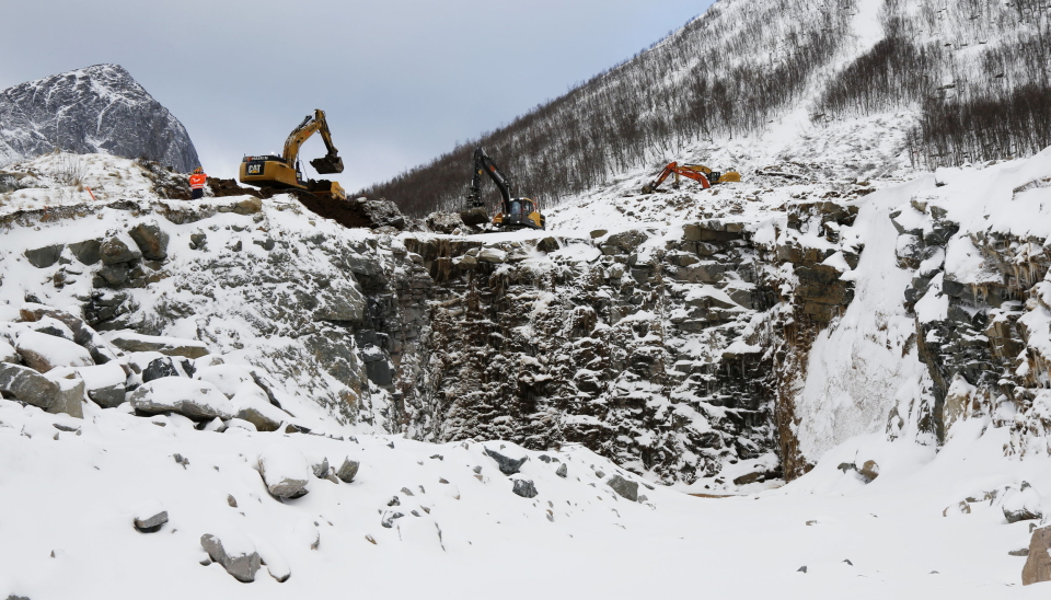 HEFTIG: En rekke maskiner er satt på jobben med å bygge et nytt led for kommende skred. Til venstre er den kjente fjelltoppen Segla som tusenvis av turister puster og peser seg til toppen av hvert år. Foto: Klaus Eriksen