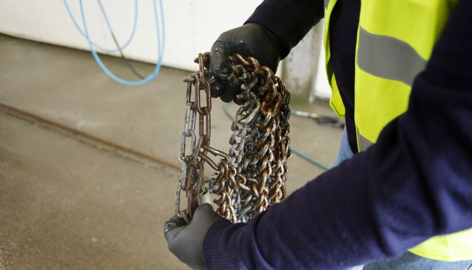 Beskytter: I tillegg til å fjerne og løse opp rustne kjettinger, blir det liggende en hinne på disse som er med på å beskytte mot at saltet fester seg og danner grobunn for mer rust. Her ser vi at halve kjettingen har ligget ca. en uke i badet, mens den andre delen ikke har vært dyppet i badet i det hele tatt.