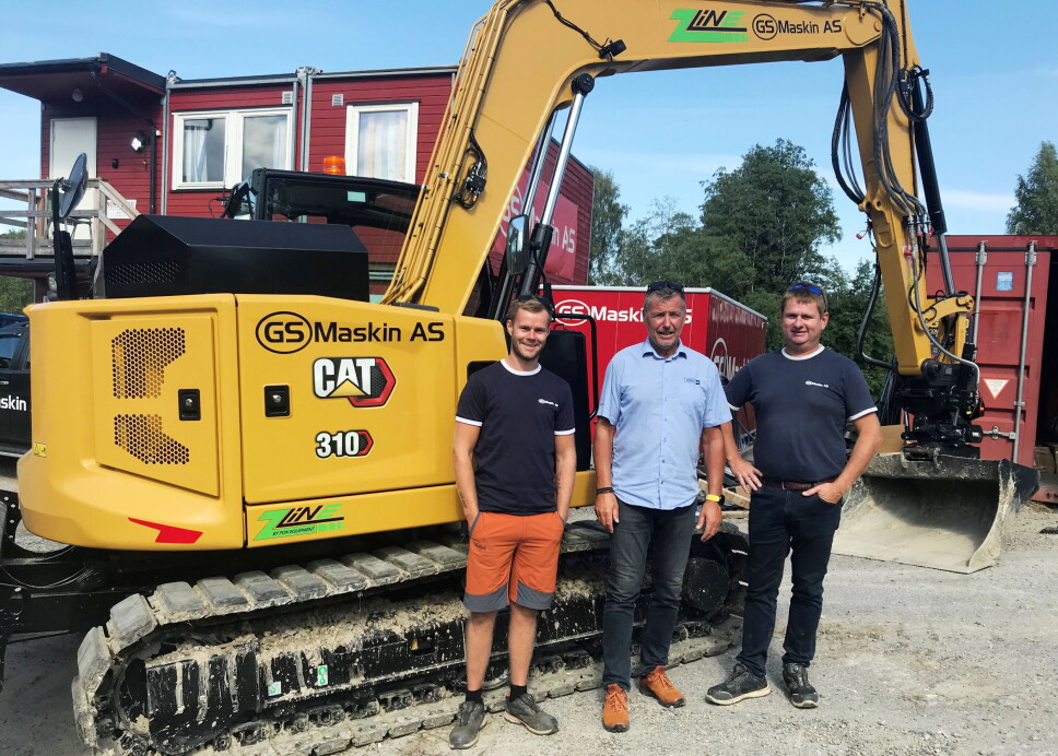 MERKEDAG: Pons Robert Hvaal (midten), eier Asbjørn Pedersen (t.h) og formann Magnus Knutsen gratulerer hverandre med prikkfri oppstart etter første ladning av el-maskinen Cat 310 Z-line. Foto: Bjørn E. Eriksen