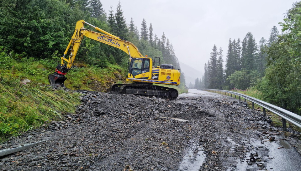 RAS: Jubileumsmaskinen i gang med opprydding av jord- og steinraset som stengte riksveien. Foto: Bjørn E. Eriksen