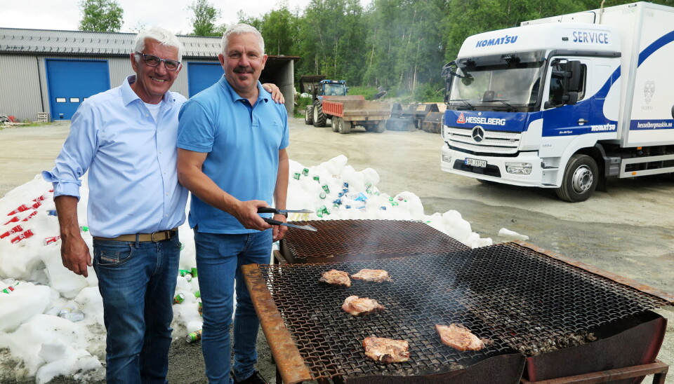 GRILLMESTRE: Dag Bråthen (t.v) og kollega Roy Mathisen hos Hesselberg Maskin var maskinleverandører og grillmestere på jubileumsarrangementet. I bakgrunnen et gedigent «kjøleskap», hentet direkte fra fjellet, til nedkjøling av drikke. Foto: Bjørn E. Eriksen