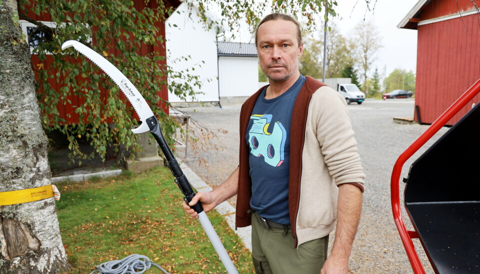 GRENSAG: Harald Smit viser hvordan den sammenfellbare tresagen virker. Blant kundene er det flere tømmerkjørere som med denne kan kutte lavthengende grener slik at de ikke skader bilen.