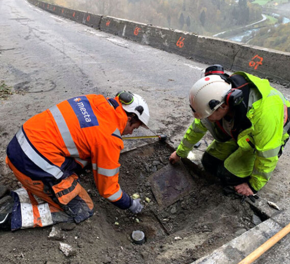 Inge Haustveit i Vestland fylkeskommune (t.h.) og Per Johnny Vadheim fra Mesta fjerner lokket over plastrøret.