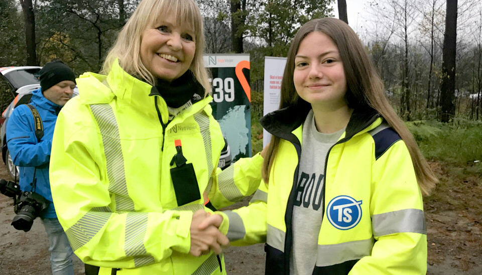 9. klassingen Henriette Omland Andersen (14) fikk æren av å ta aller første gravestikk i prosjektet. Målet er at hun kommer tilbake om fire år og som fersk sjåfør er først til å kjøre på veien. Her gratuleres hun av Nye Veiers administrerende direktør Anette Aanesland.