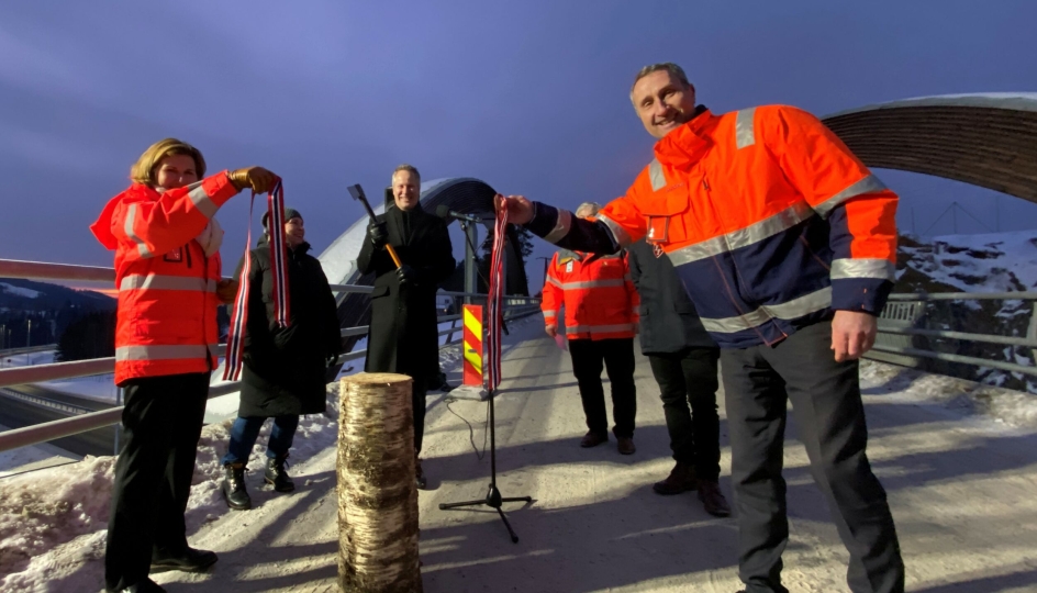 Samferdselsminister Jon-Ivar Nygård svingte øksa og kuttet snora på ny E16 i Jevnaker med assistanse fra vegdirektør Ingrid Dahl Hovland og Skanska-direktør Ståle Rød. Skanska og Vegvesenet har kuttet klimagassutslippene fra vegprosjektet kraftig.