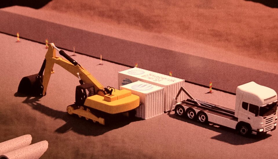 Krokbil leverer og henter containerne. Den største containeren er en battericontainer og den lille er en lade/omformer-container som gravemaskiner lades via. Krokbil leverer og henter containerne. Den største containeren er en battericontainer og den lille er en lade/omformer-container som gravemaskiner lades via.