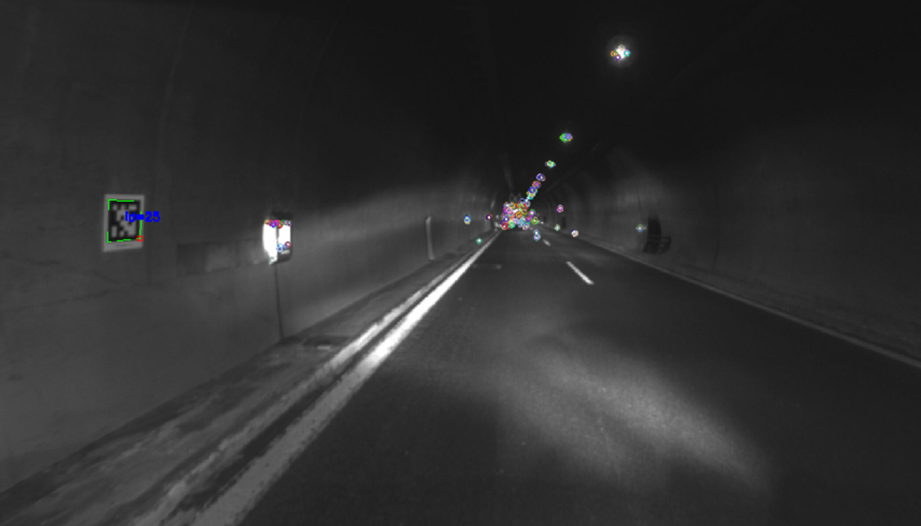 Dette bildet er tatt av kameraet på robotkjøretøyet. For at roboten skal kunne lokalisere seg selv, gjør den en rekke markeringer (som er de fargede markeringene i bildet) i tunnelen. Disse markeringene brukes av posisjoneringsalgoritmen.