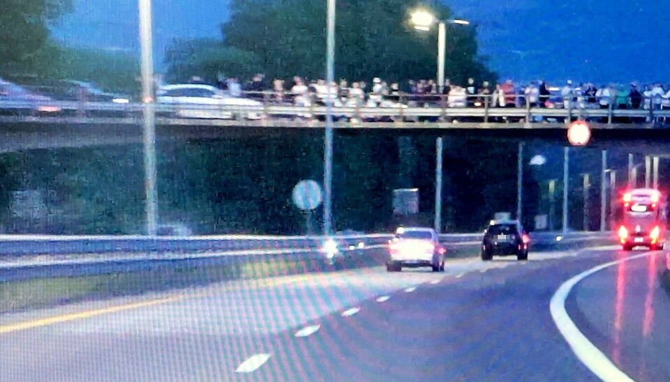 HØY HASTIGHET: Det ble målt over 200 km/t da politiet fulgte etter de to kappkjørerne ned mot Kjellstad. På bildet er de to bilene i ferd med å passere en buss, mens en 'heiagjeng' står på brua over europaveien.