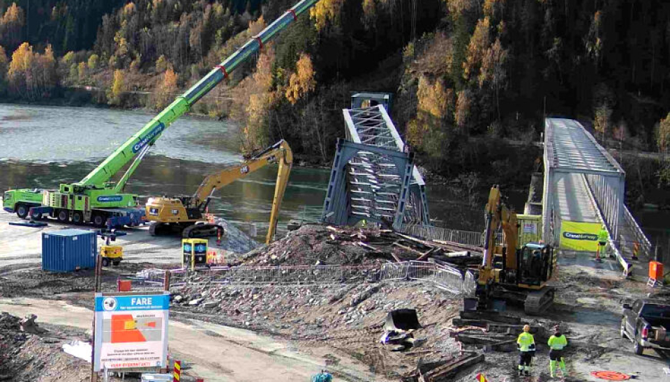 JERNBANEBRU OG VEIBRU: Jernbanebrua over Gudbrandsdalslågen ved Ringebu (i Ringebu kommune) falt ned i elva etter ekstremværet Hans tidligere i år. Nå arbeides det med å reparere denne. Arbeidet vil ta flere måneder. Deretter skal den gamle jernbanebrua (til høyre), som nå er en del av fylkesvei 319, repareres. Det er laget en fylling i elva på nordsiden for jernbanereparasjonen, mens det skal lages en fylling på sørsiden for fylkesveiarbeidet.