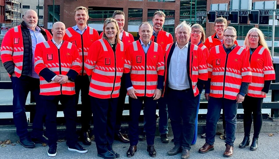 LAGET SAMLET: Her står alle de som var til stede under signeringen rett ved stedet der prosjektet starter. Bak fra venstre: Roy Lund, Eiffage Norge, Hans Christian Loland, Repstad Anlegg, Bernt Olav Holen, Repstad Anlegg, Rune Galteland, hovedbyggeleder, Statens vegvesen, Ingunn Foss, prosjektdirektør, Statens Vegvesen, Trygve Håland, prosjekteringsleder Statens vegvesen, Gunn Brungot, Rambøll Norge. Foran fra venstre: Bjørn Inge Rundtom, Rambøll Norge, statssekretær Cecilie Knibe Kroglund (Ap), Vincent Papait, daglig leder Eiffage Norge, Kjell Inge Davik, direktør for divisjon Utbygging i Statens vegvesen og Jan Helge Egeland, prosjektleder E18/E39 Gartnerløkka-Kolsdalen.