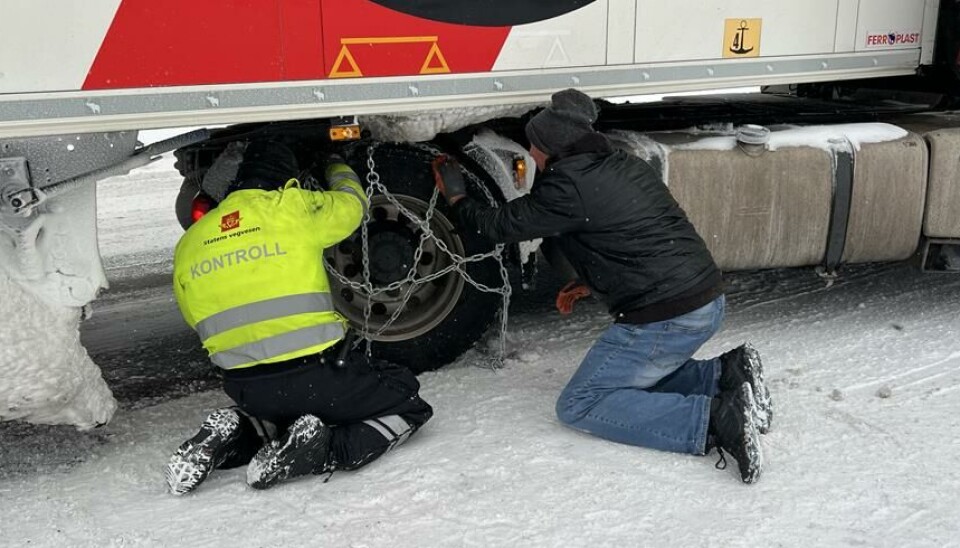 HJELP: Kontrollør Daniel Alexander Hals hjelper en sjåfør å legge på kjettinger på Langhus utenfor Oslo.